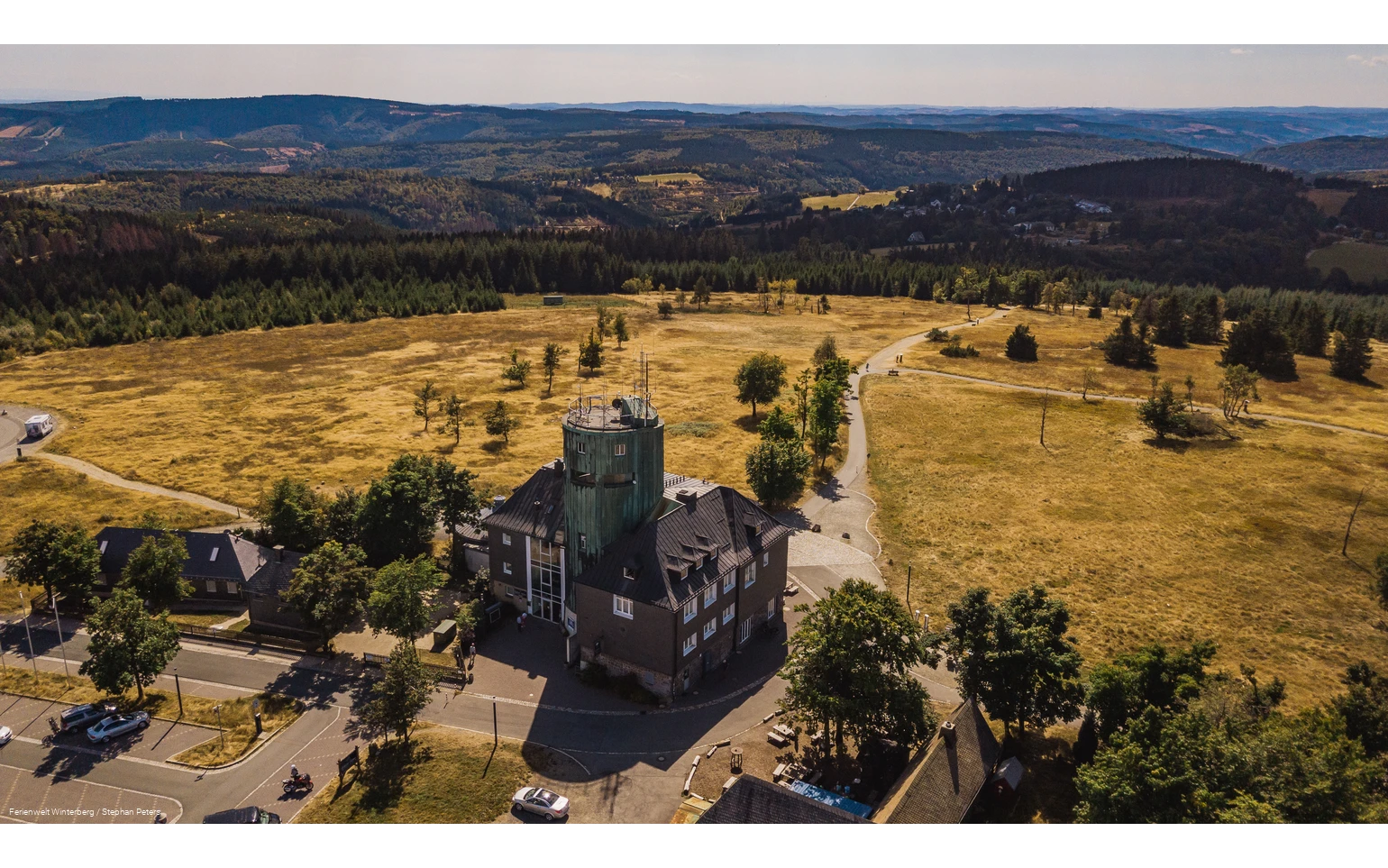 Drohnenaufnahme vom Astenturm mit der Wetterstation umgeben von weiter Heidelandschaft und Wäldern.