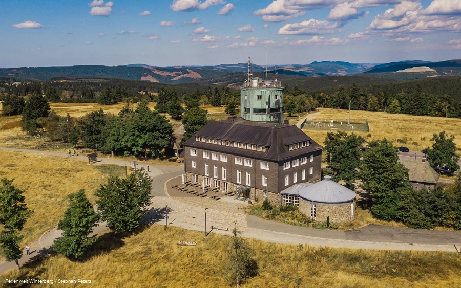Drohnenaufnahme vom Astenturm mit Wetterstation umgeben von Heidelandschaft und Wäldern.