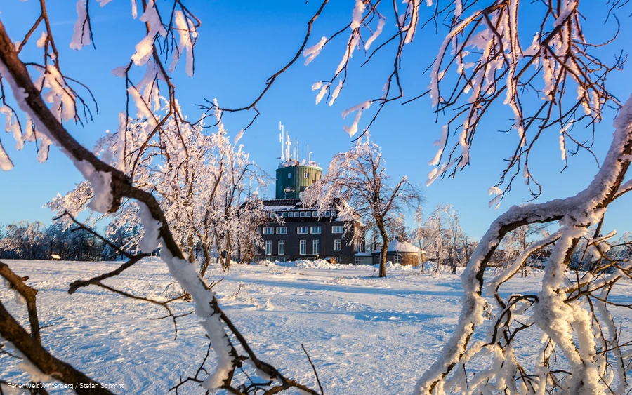 Der Astenturm umgeben von einer Schneelandschaft bei Sonnenschein.