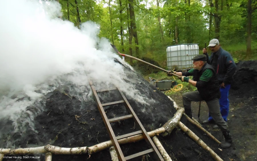 Anzünden des Holzkohlenmeilers Anzünden des Holzkohlenmeilers