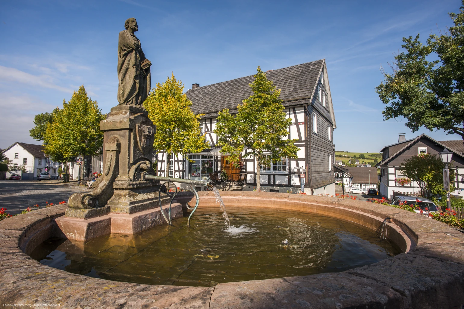 Brunnen umgeben von Fachwerkhäusern.